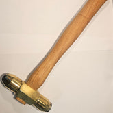 Brass hammer with two different carbide faces with wooden handle on a white background