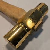 brass hammer with wooden handle on a white background