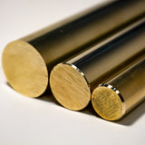 Three brass round bars cut to length showing polished end faces and golden finish
