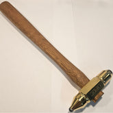 Hammer with wooden handle and brass head with round carbide inserts on a light background