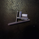 different size Stainless Steel Flat bar pieces arranged and photographed on a dark textured surface under direct light.
