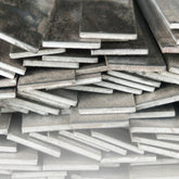 Bundle of stainless steel flat bar cut to different lengths and widths on white background