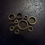 Top-down view of brass round tube cut sections showing range of available diameters on dark background