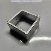 aluminium square object on a reflective surface