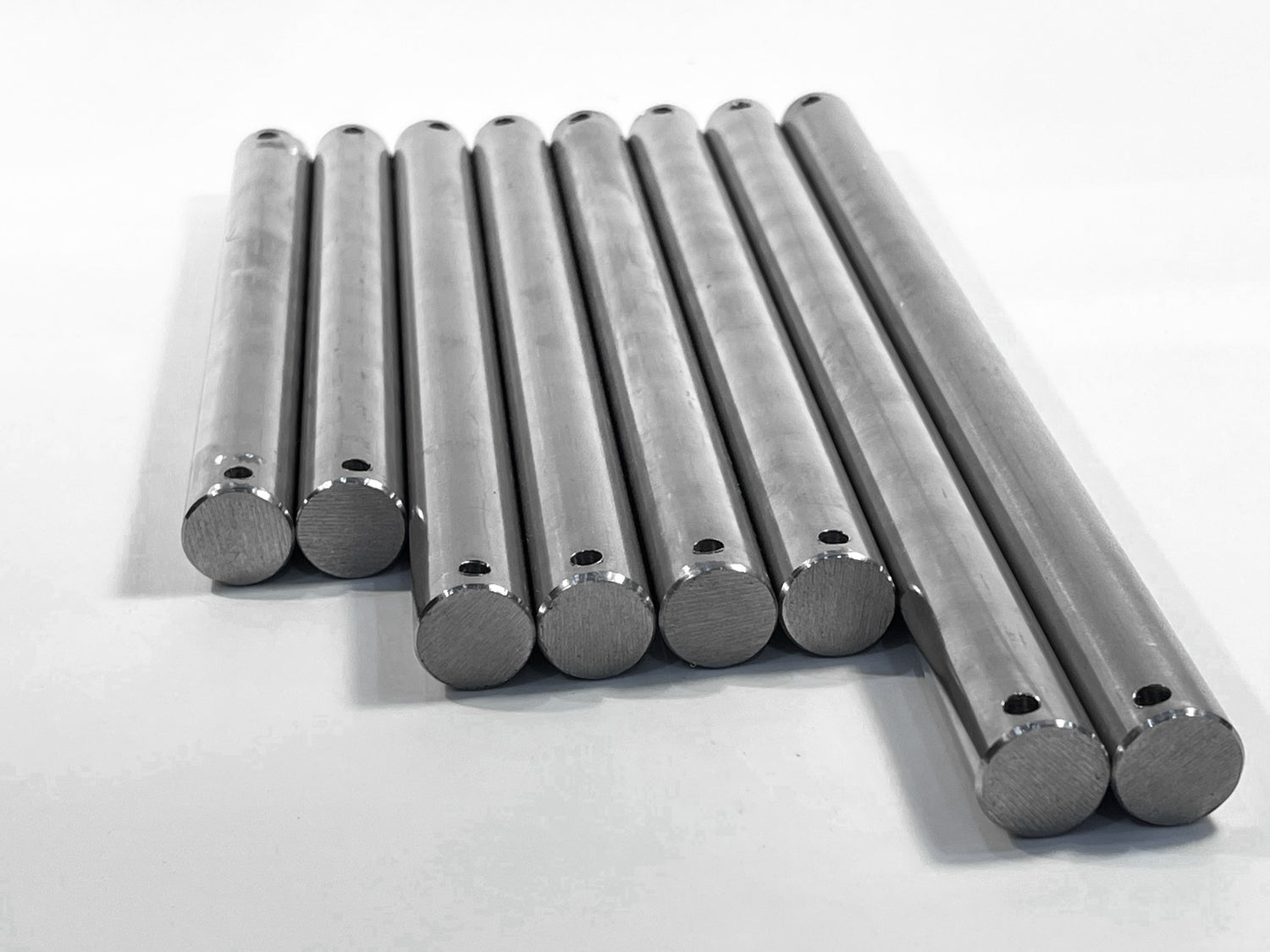 A selection of stainless steel boat trailer roller spindles lined up in a row