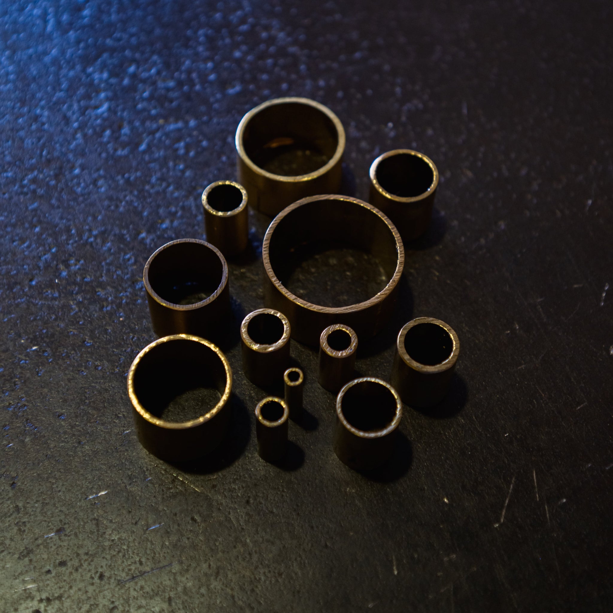 Angled view of brass round tube cut sections showing hollow ends and range of available diameters