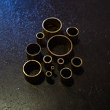 Angled view of brass round tube cut sections showing hollow ends and range of available diameters