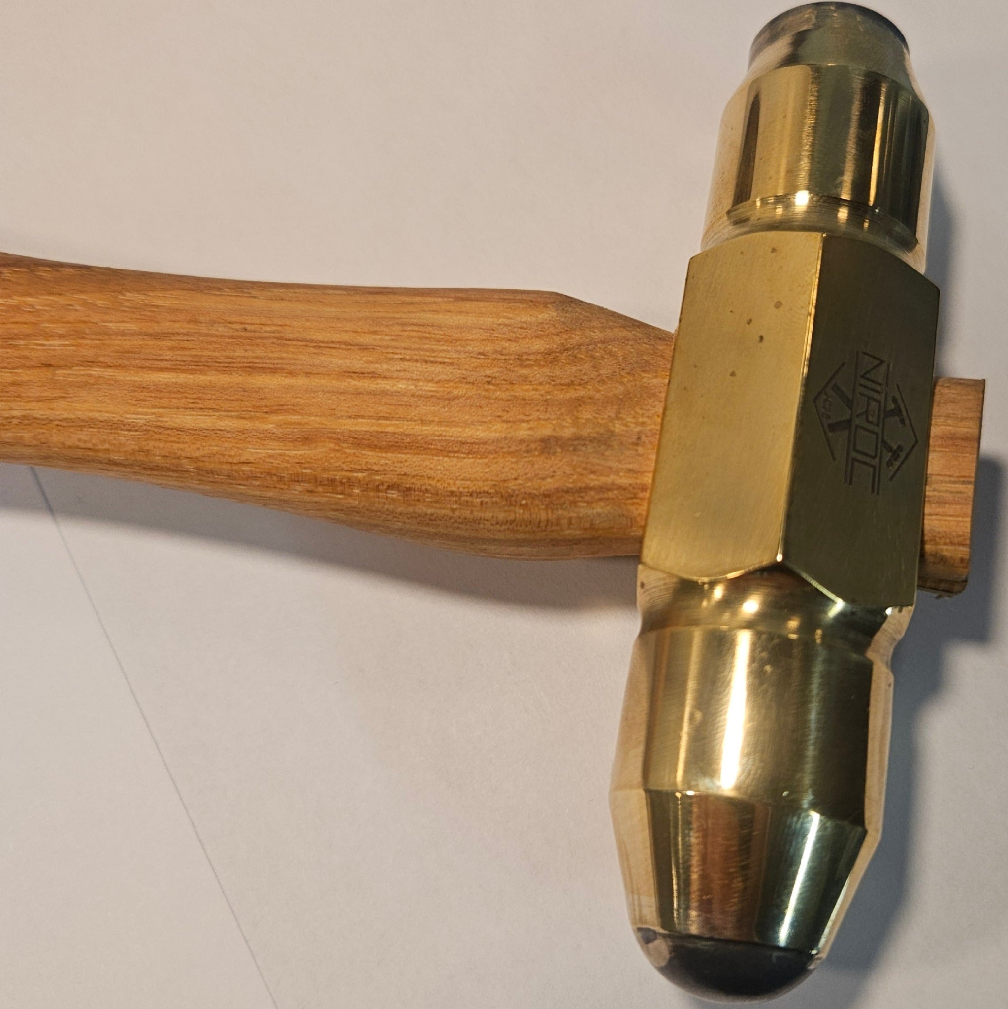 Brass hammer with carbide faces and a  wooden handle on a white background