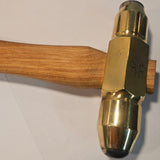 Brass hammer with carbide faces and a  wooden handle on a white background