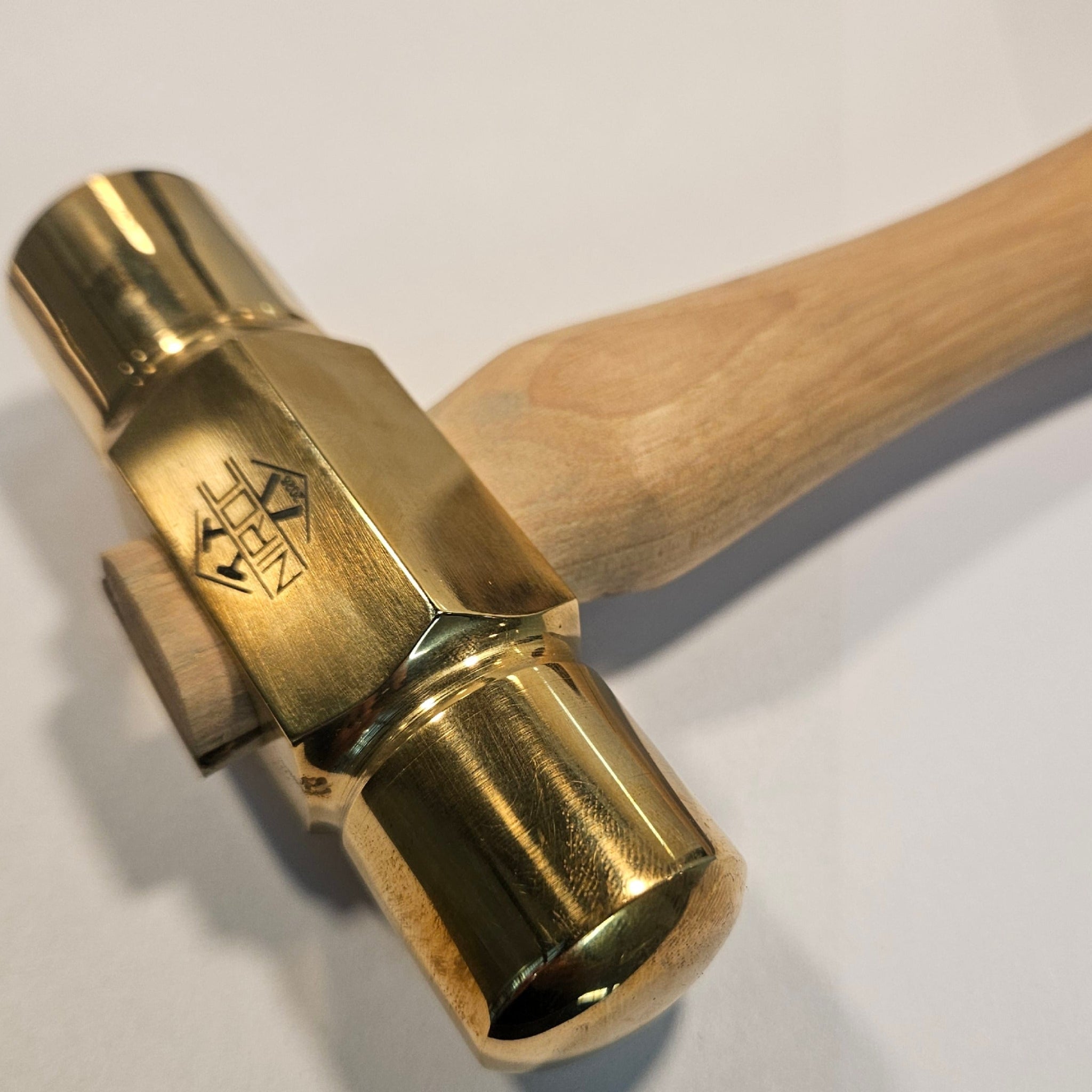 brass hammer with a wooden handle on a white background