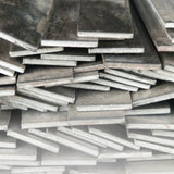Bundle of stainless steel flat bar cut to different lengths and widths on white background