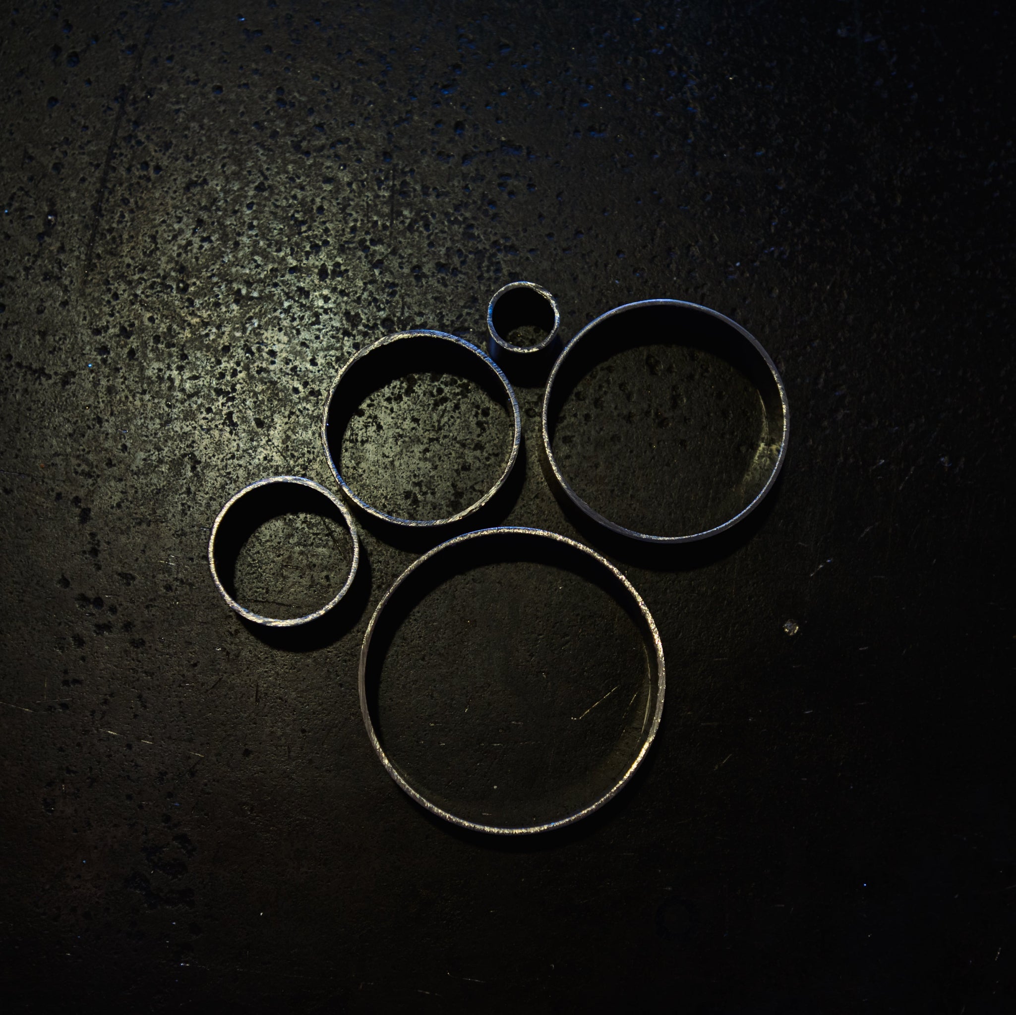 Top-down view of 304 stainless steel round tube cut sections showing range of available diameters on dark background
