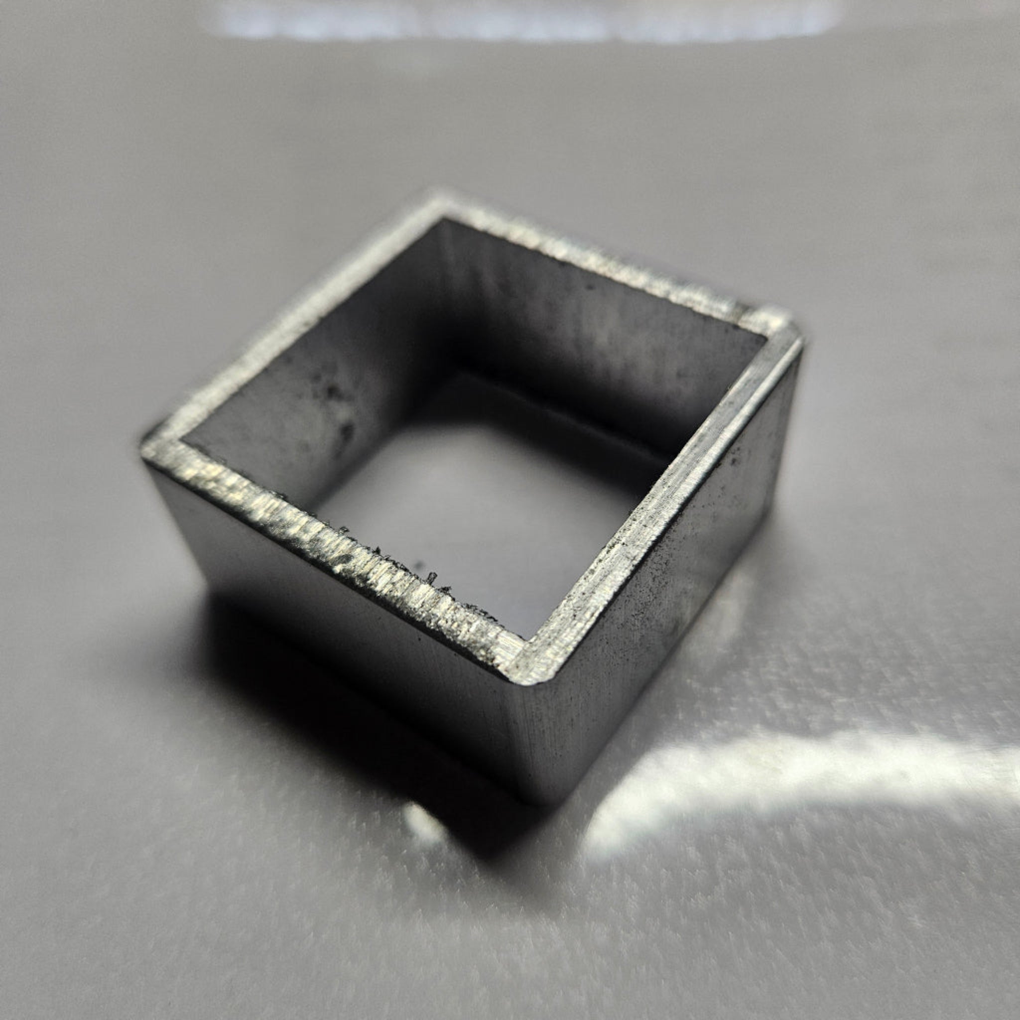 aluminium square object on a reflective surface