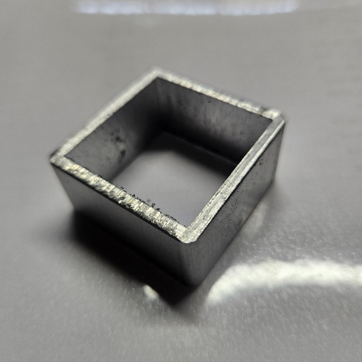 aluminium square object on a reflective surface