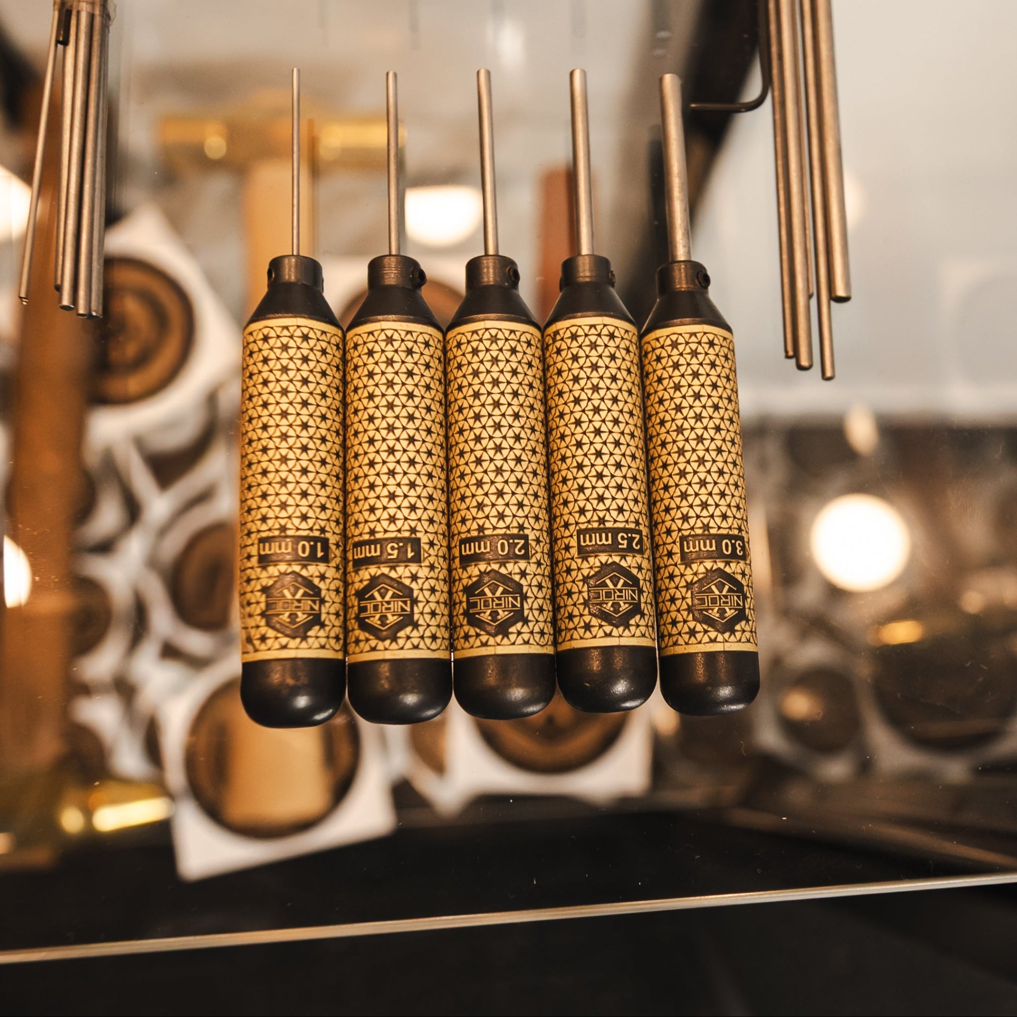 A set of 5 blackened brass pin punches with star pattern handles